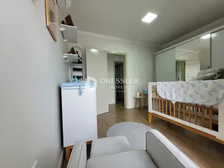 Quarto com cama de madeira e armário branco em ambiente claro.