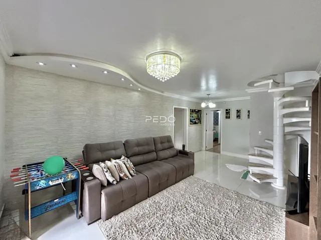 Sala de estar com um sofá grande e tapete claro.