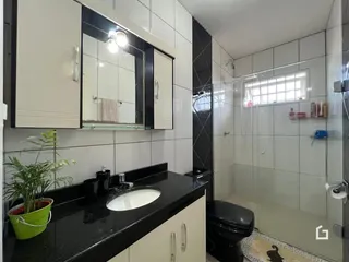 Interior de um banheiro com revestimento cerâmico nas paredes e piso.