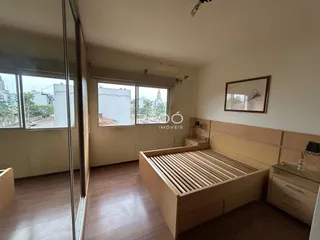 Quarto com piso de madeira e grandes janelas em um imóvel em Lajeado.