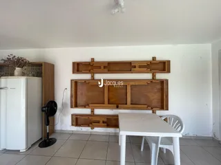 Foto de uma sala de jantar com painel de madeira e geladeira branca.