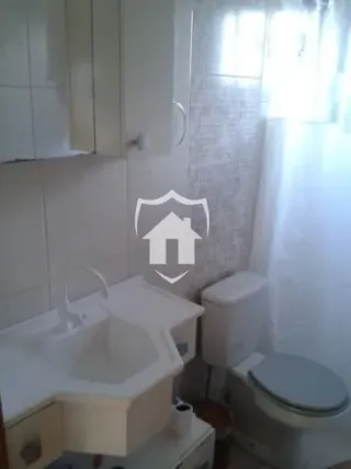 Foto de um banheiro com paredes brancas e azulejos claros.