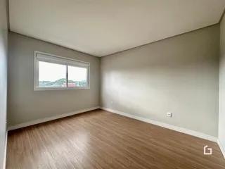 Foto de um cômodo interno com paredes claras e piso de madeira.