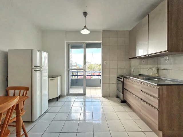 Interior da cozinha com piso de cerâmica e portas de vidro.