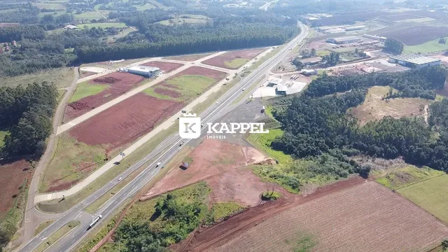 Vista aérea de uma área rural com estrada e campos agrícolas.
