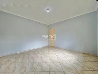 Interior de uma sala com piso de cerâmica e porta de madeira.