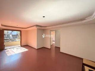 Sala de estar com piso de madeira e porta de entrada.