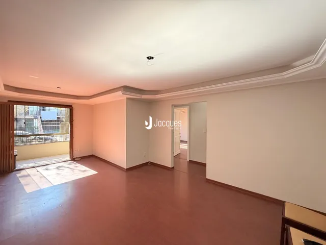 Sala de estar com piso de madeira e porta de entrada.