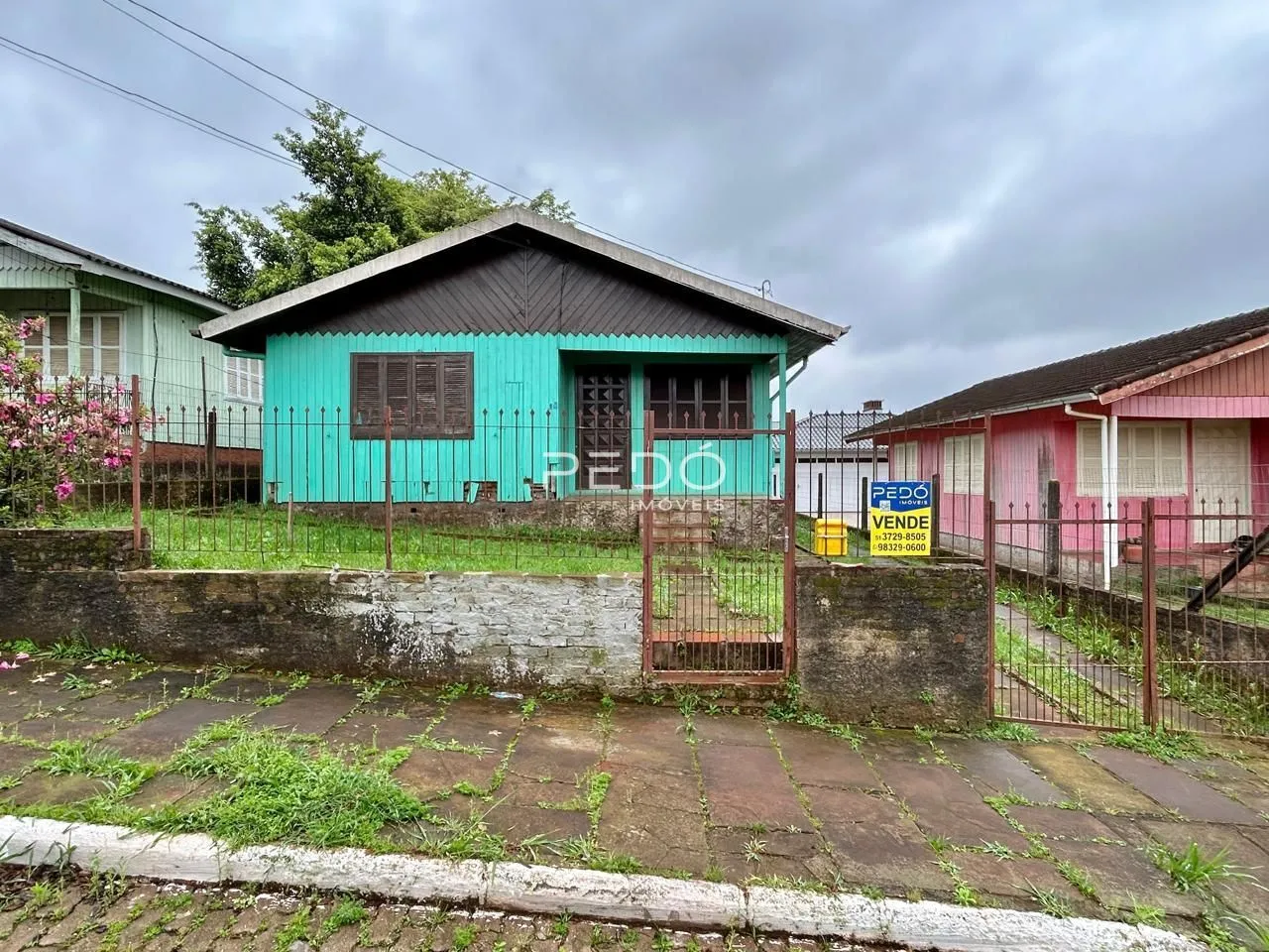 Fachada de uma casa em Lajeado, Brasil, com cerca e muro de alvenaria.