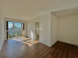 Uma sala de estar com piso de madeira e grande janela.