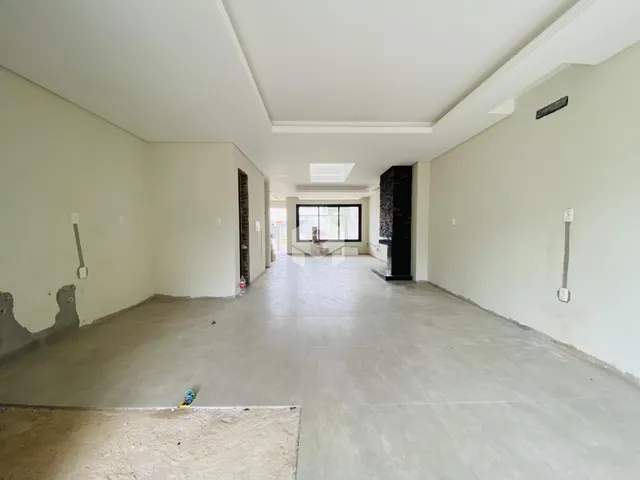 Hall de entrada com paredes brancas e piso de concreto em uma propriedade.