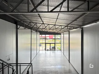 Interior de um espaço comercial com teto de estrutura metálica exposta.