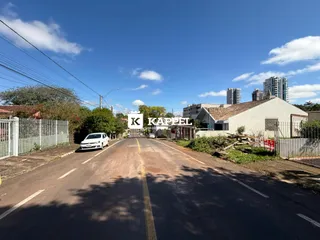 Vista da rua mostrando uma edificação simples ao lado de uma estrada.