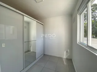 Hall de entrada com portas de correr e piso de cerâmica clara.