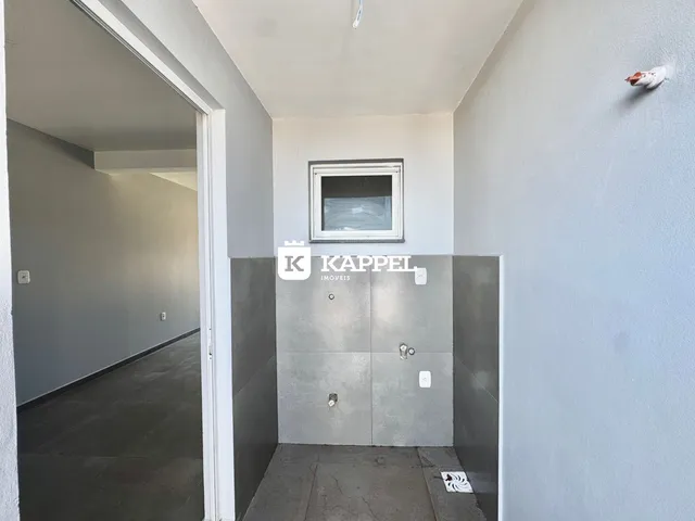 Hall de entrada interno com paredes cinzas e uma abertura para outro corredor.