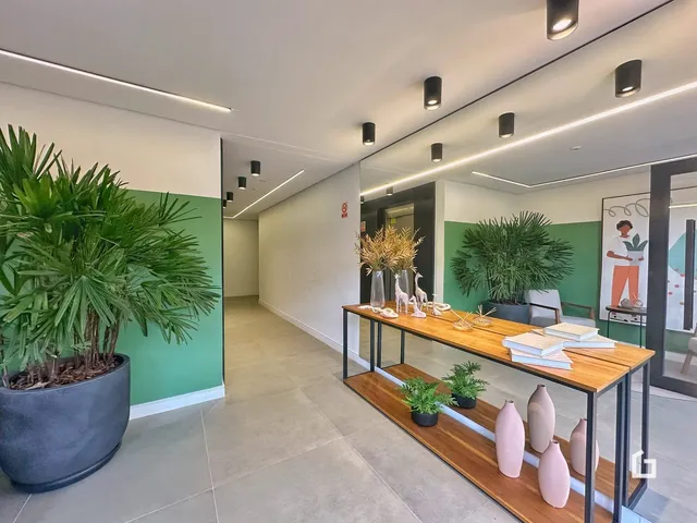 Hall de entrada com paredes verdes e piso claro.