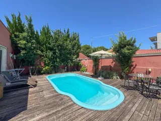 Vista externa de uma piscina e deck em uma propriedade.