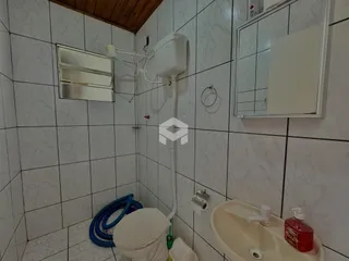 Foto de um banheiro com revestimento de azulejos brancos.
