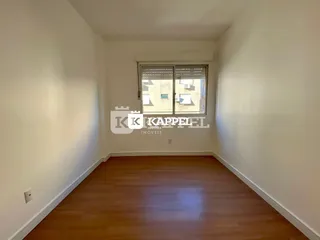 Foto de uma sala de estar com piso de madeira e janela.
