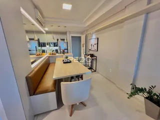 Ambiente interno com mesa de jantar e bancada em um apartamento em Lajeado.