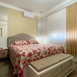 Quarto com cama e cortinas claras em um imóvel.