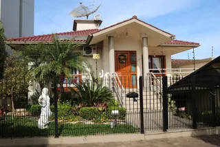 Fachada de uma residência em Lajeado, Brasil com cerca e jardim.