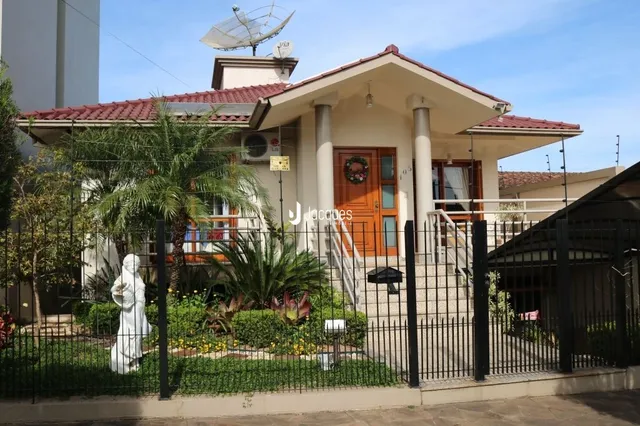Fachada de uma residência em Lajeado, Brasil com cerca e jardim.