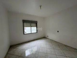 Ambiente interno de uma sala com piso de cerâmica e janela.