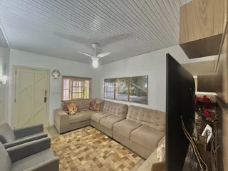 Sala de estar com sofá e piso de ladrilhos no interior de uma residência.