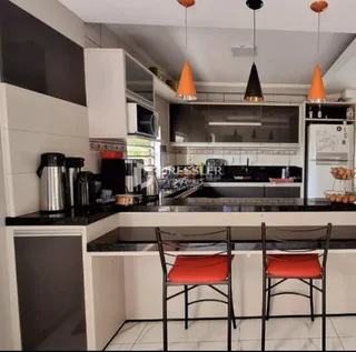 Cozinha moderna com armários brancos e bancadas escuras.