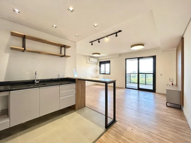 Cozinha moderna com armários brancos e piso de madeira clara.