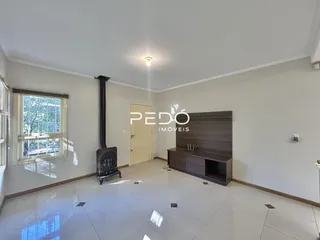 Vista interna de uma sala com piso de cerâmica e parede branca.