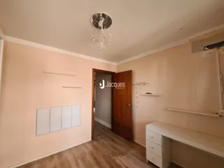Hall de entrada com paredes claras e piso de madeira em um imóvel no Brasil.