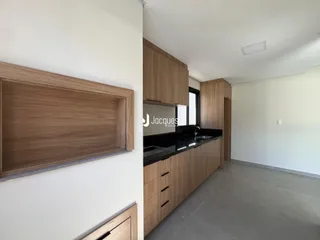 Vista da cozinha moderna com armários de madeira e bancada escura.
