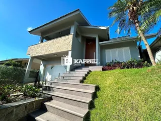 Vista externa de uma casa moderna em Lajeado com jardim gramado e escadaria.