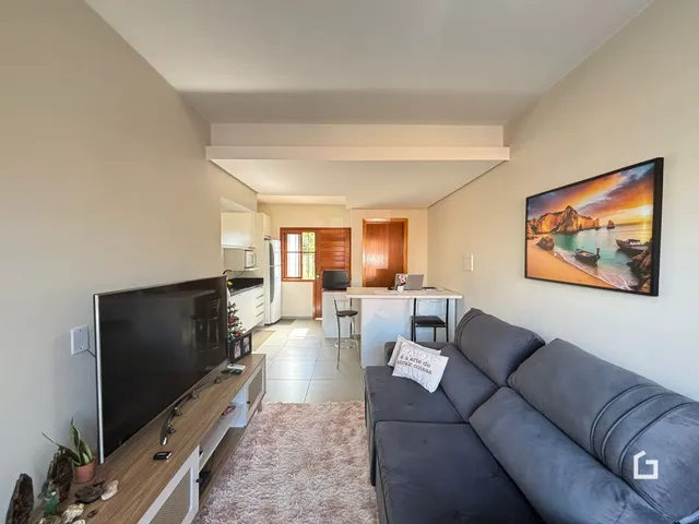 Sala de estar com sofá e televisão em um apartamento.