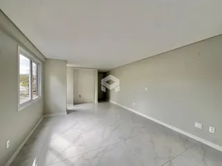 Ambiente interno de uma sala ampla com piso de cerâmica e janela.