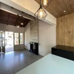 Interior com painel de madeira e teto branco em um ambiente residencial.