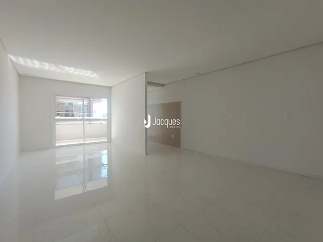 Ambiente interno amplo com piso claro e paredes brancas.