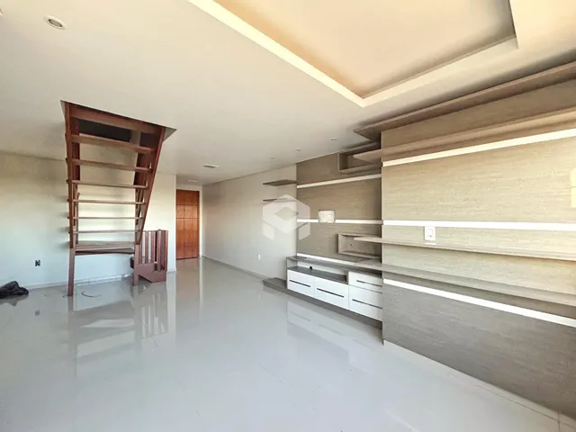 Interior de uma sala de estar ampla com piso claro e paredes brancas.