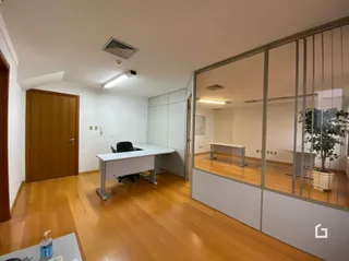 Interior de uma sala com piso de madeira clara e portas de madeira.