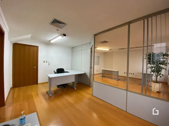 Interior de uma sala com piso de madeira clara e portas de madeira.