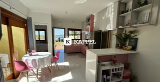 Sala de estar com mesa de jantar e armários embutidos em um apartamento em Lajeado.