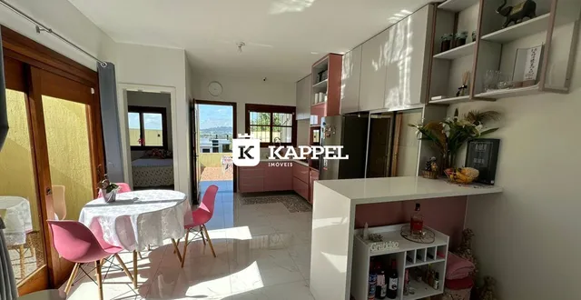 Sala de estar com mesa de jantar e armários embutidos em um apartamento em Lajeado.