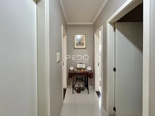 Hall de entrada com paredes brancas e piso claro.