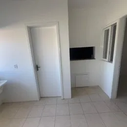 Foto de um cômodo interno com paredes brancas e piso de cerâmica.