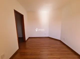 Ambiente interno com piso de madeira clara e paredes brancas.