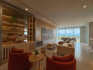 Sala de estar moderna com grandes janelas e vista panorâmica.