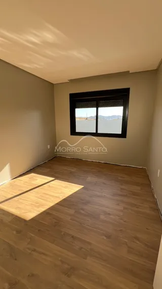 Foto de um cômodo interno com piso de madeira e janela.