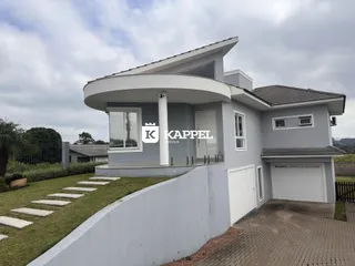 Fachada moderna de uma casa em Lajeado, Brasil, com varanda e garagem.